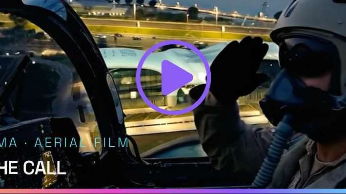 A fighter pilot salutes from the cockpit over a city at dusk, from The Call